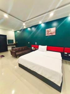 a bedroom with a large bed and a couch at Hưng Phú Hotel HCM in Ho Chi Minh City