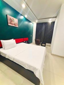 a bedroom with a bed and a green wall at Hưng Phú Hotel HCM in Ho Chi Minh City