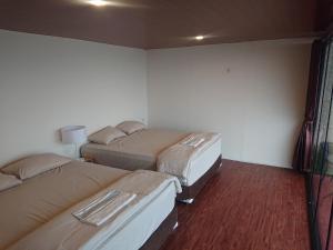 a room with three beds in a room at Dieng Latar Alam Tambi Syariah in Kejajar