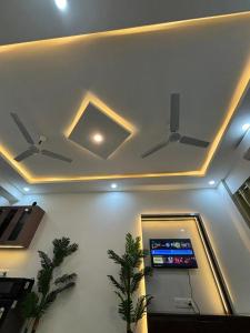 a room with two ceiling fans and a game console at isuites in Ghaziabad +10 photos