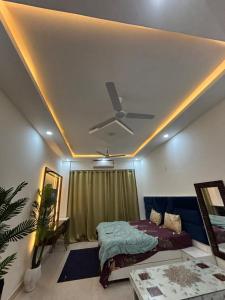 a bedroom with a ceiling fan and a bed at isuites in Ghaziabad