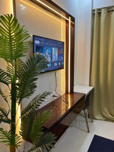 a room with a desk with a tv and a plant at isuites in Ghaziabad