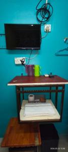 a shelf with a tv on a blue wall at hotel hen hen in Kampong Saleng