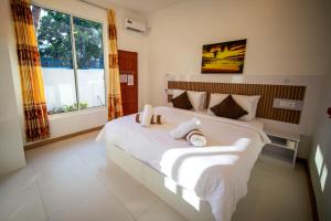 a bedroom with a large bed with white sheets and pillows at Velana View at Mathiveri in Mathiveri