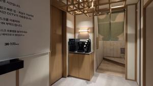 a room with a microwave and a room with writing on the wall at Anook Ryokan Hotel Eunpyeong Bulgwang in Seoul