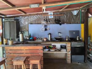 a kitchen with a stove and a table in it at Hostal & Dormitorio Buena Onda in Palomino