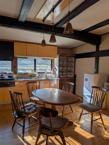 a kitchen with a table and chairs in a room at ゲストハウス山音 in Takayama
