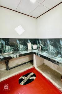 a kitchen with a counter and a red floor at TM Villa Madiha in Matara +3 photos