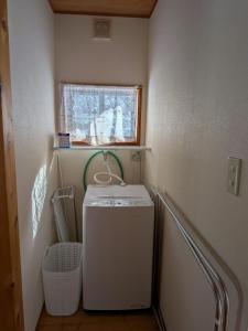 a washing machine in a small room with a window at ゲストハウス山音 in Takayama