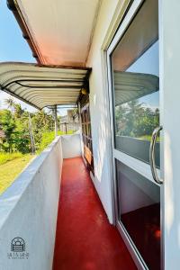 an open door to a balcony with a red floor at TM Villa Madiha in Matara