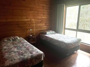 a bedroom with two beds and a window at For Rest at Crescent Head in Crescent Head