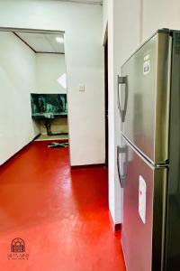 a refrigerator in a room with a red floor at TM Villa Madiha in Matara