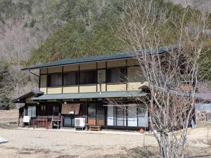 a house with black windows and a mountain at ゲストハウス山音 in Takayama