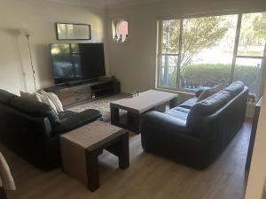 a living room with two couches and a television at Cosy and convenient in Lynbrook in Lyndhurst