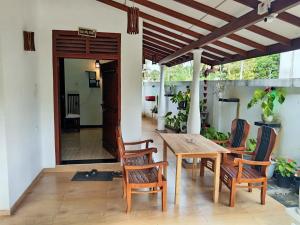 a patio with a wooden table and chairs and a door at Southern Surf Villa in Dickwella