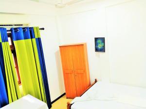 a room with a bed and a wooden door at Southern Surf Villa in Dickwella