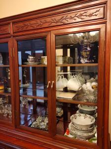 a wooden cabinet with plates and dishes in it at Two Bedroom Suite with Private Bathroom and Shared Lounge in West Kelowna +20 photos