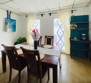 a dining room table with a vase of flowers on it at Hostal La casa de Ross in Santa Ana +26 photos