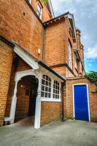 Un edificio de ladrillo con una puerta azul. en St Margaret's Hotel en Oxford