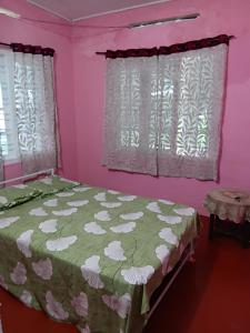 a bedroom with a bed and pink walls at Misty Moutain view in Pīrmed