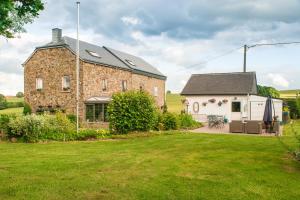 ein großes Backsteinhaus mit einem Rasenhof in der Unterkunft B&B La Niouche in La-Roche-en-Ardenne