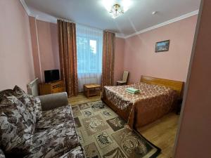 a bedroom with a bed and a couch at Hotel Nurlytau in Borovoye