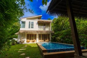 a villa with a swimming pool in front of a house at Santi Villa Wat Seree in Ko Phangan