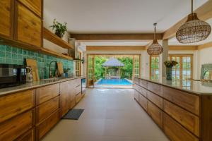a kitchen with wooden cabinets and a pool in the background at Santi Villa Wat Seree in Ko Phangan