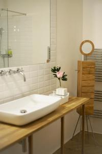 a bathroom with a sink and a flower on a counter at 0.3 Stanze in Trieste