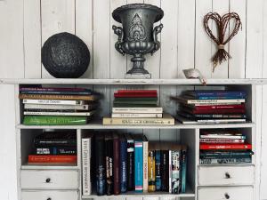 a book shelf filled with books and a vase at Mellby 11 Bed & Breakfast in Kivik
