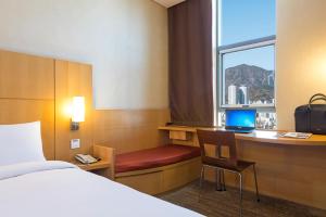 a hotel room with a bed and a desk with a laptop at Central Seven Hotel by Kwon Busan Seomyeon in Busan