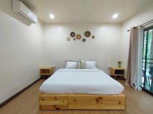 a bedroom with a white bed and a window at Suanthara kokut in Ko Kood