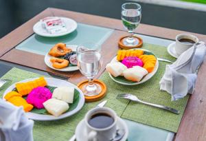 a table with plates of food and glasses of wine at DWM Mandhasativa Homestay By Reccoma in Singaraja
