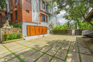 a courtyard in front of a house with an orange gate at DWM Mandhasativa Homestay By Reccoma in Singaraja