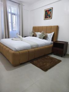 a large bed with a brown couch in a bedroom at Fan Farm Stay in Munyu