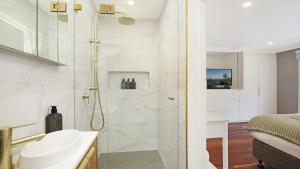 a bathroom with a shower and a sink at Arcadia Cottage in Bowral