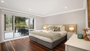 a bedroom with a bed and a balcony at Arcadia Cottage in Bowral
