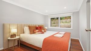 a bedroom with a large bed with a window at Arcadia Cottage in Bowral