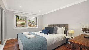 a bedroom with a bed with two towels on it at Arcadia Cottage in Bowral +31 photos