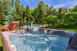 a hot tub in a backyard with a pool at Fiddler Lake Resort - Deer 73 in Mille-Isles