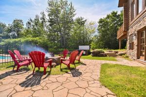 a group of red chairs around a fire pit at Fiddler Lake Resort - Deer 73 in Mille-Isles