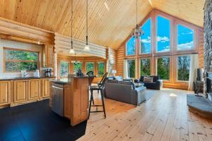 a kitchen and living room in a log cabin at Fiddler Lake Resort - Deer 73 in Mille-Isles +21 photos