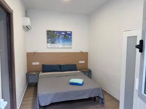 a bedroom with a bed with a blue pillow on it at Rooms Burjassot in Burjassot