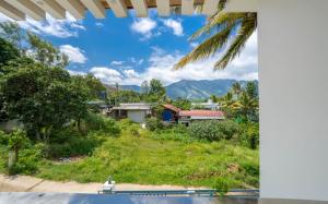 a view of a village with mountains in the background at Le Sancta homestay in Maraiyūr