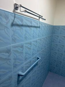 a blue tiled shower with a towel rack in a bathroom at Restora Ella in Ella +56 photos