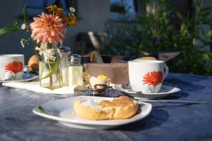 einen Tisch mit Teller mit Speisen und Tassen Kaffee in der Unterkunft Ferienzimmer Am Brauhausgraben in Lübbenau