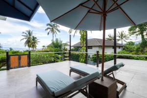 a patio with two chairs and an umbrella at Kimana Villa in Manggis
