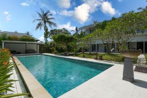 a swimming pool in front of a house at Kimana Villa in Manggis