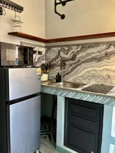 a kitchen with a refrigerator and a sink at Mersey Residence Koh Samui in Lamai