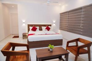 a bedroom with a bed and a table and chairs at Le Sancta homestay in Maraiyūr